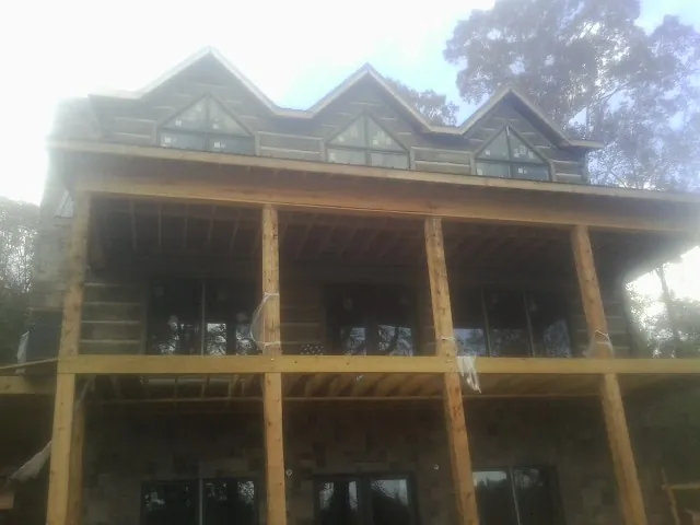 Dormers and porch framing on a large log home under construction — Roof Coating work by our crew in Washingtonville