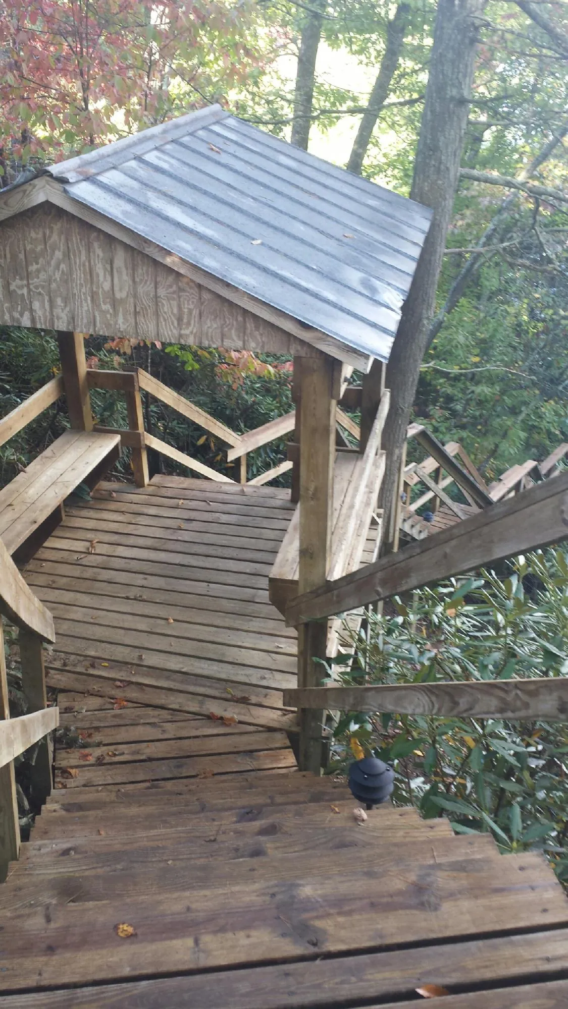 Metal roofed shelter over wooden steps on a wooded walkway — Skylight Repair & Installation work by our crew in Washingtonville
